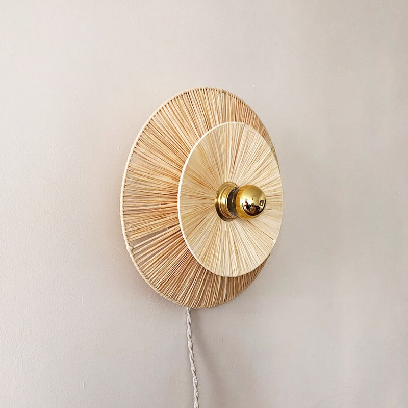 Round woven flower wall sconce with a brass center