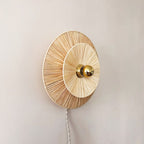 Round woven flower wall sconce with a brass center