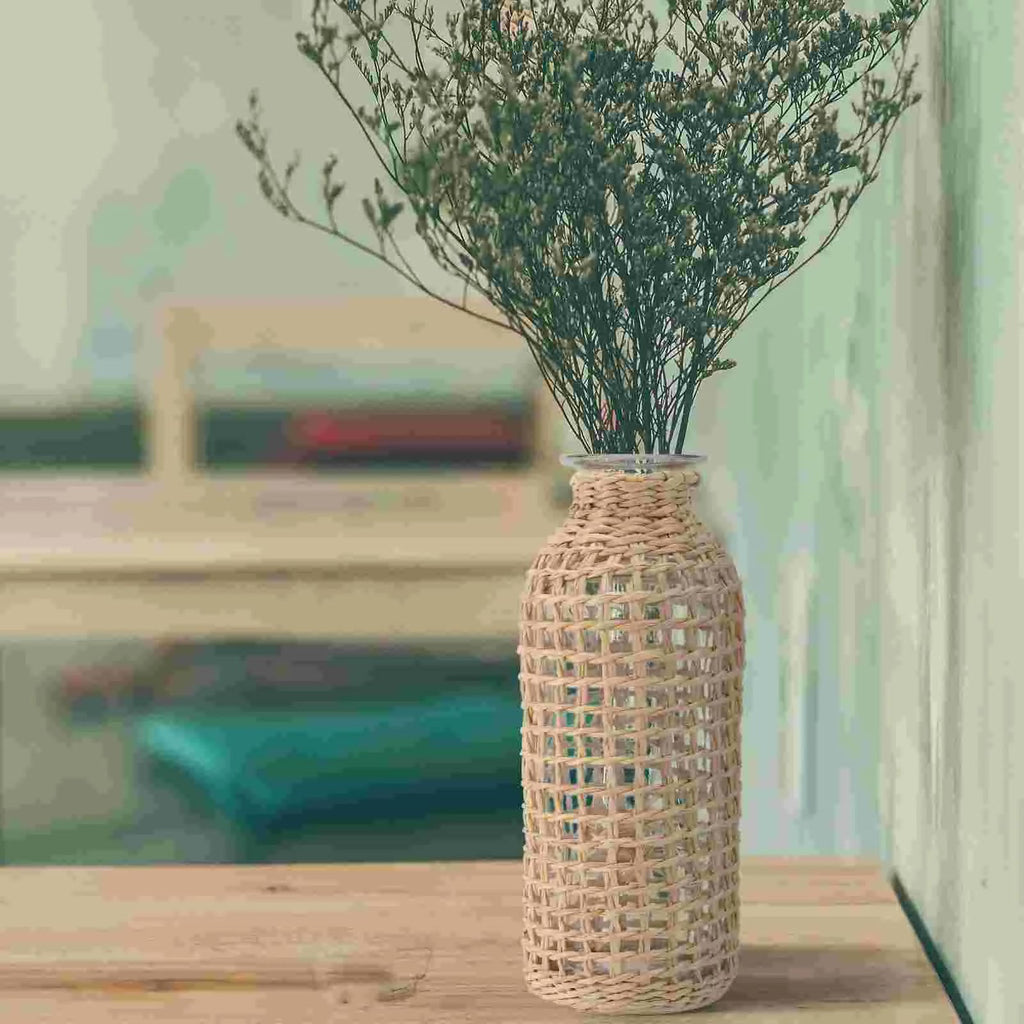 Glass bottle vase wrapped in an open woven wicker net