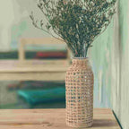 Glass bottle vase wrapped in an open woven wicker net