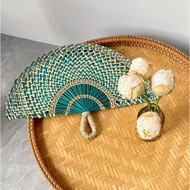 Half moon woven hand fan with colored radiating ribs and a loop handle