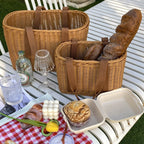 Two woven picnic tote baskets with soft handles on a picnic blanket