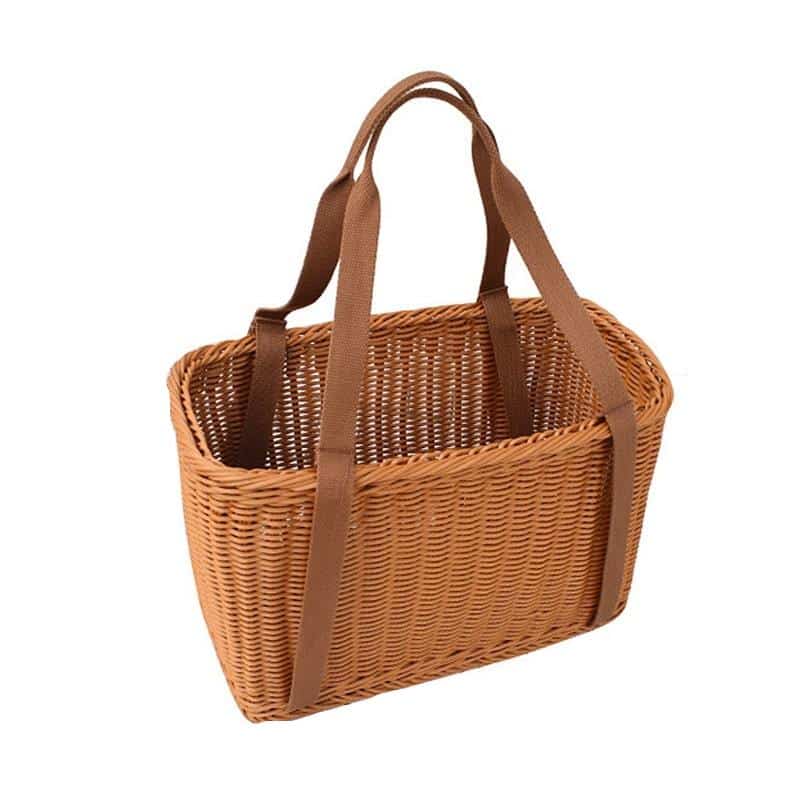 Two woven picnic tote baskets with soft handles on a picnic blanket