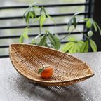 Boat shaped hand woven rattan fruit basket on a kitchen counter
