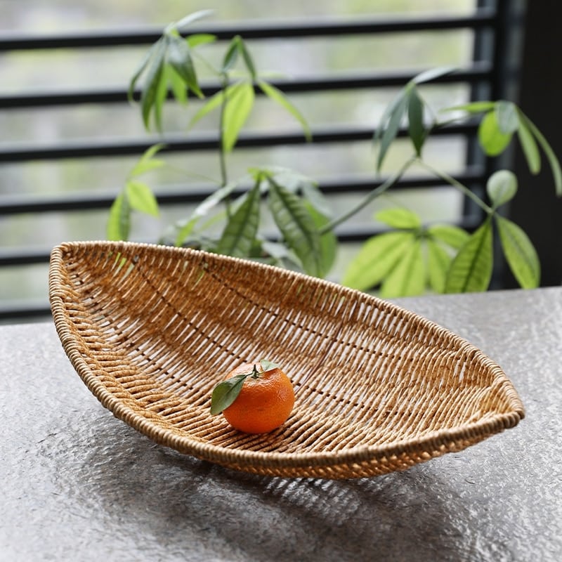Boat shaped hand woven rattan fruit basket on a kitchen counter
