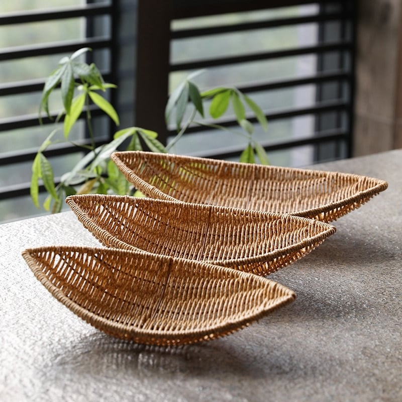 Boat shaped hand woven rattan fruit basket on a kitchen counter