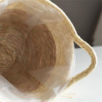 Round hand woven rattan planter trimmed with white pompom fringe