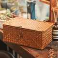 Rectangular woven rattan storage box with a lid, latch and side handles