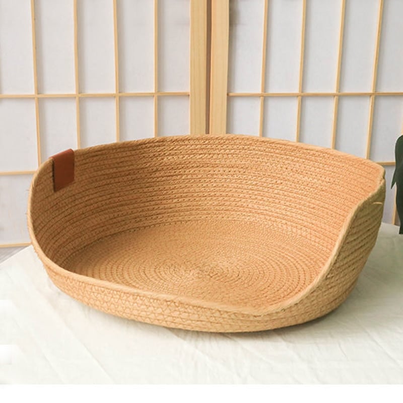 Round woven dog bed with a low front entry