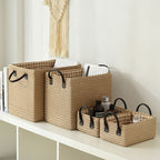 Woven storage boxes with leather look handles on a shelf