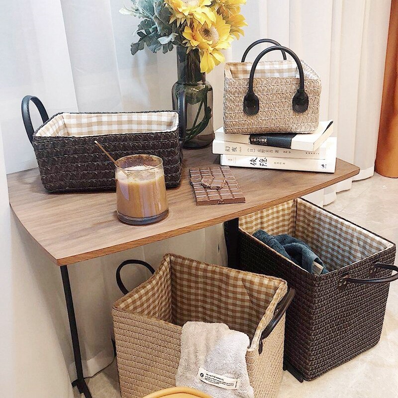 Woven storage boxes with leather look handles on a shelf