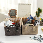 Woven storage boxes with leather look handles on a shelf