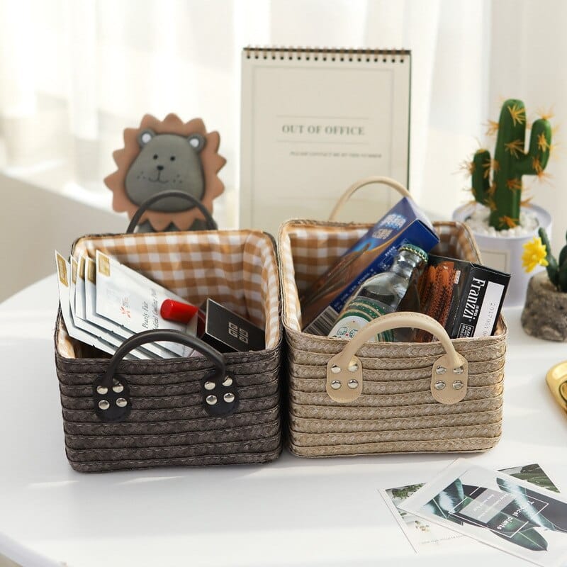 Woven storage boxes with leather look handles on a shelf