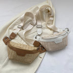 Small elongated woven straw sling bag with an adjustable strap