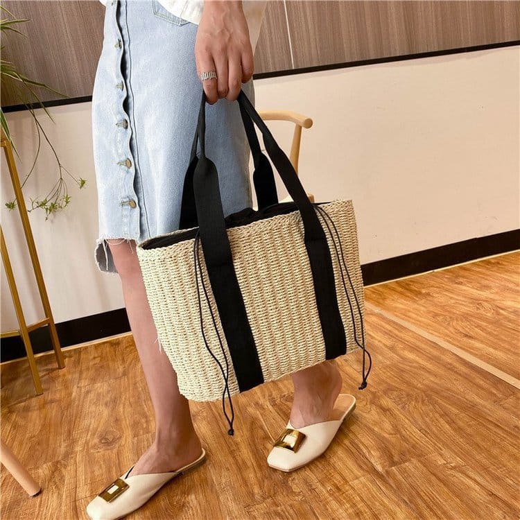 Tightly woven straw handbag with an adjustable strap and inner phone pocket