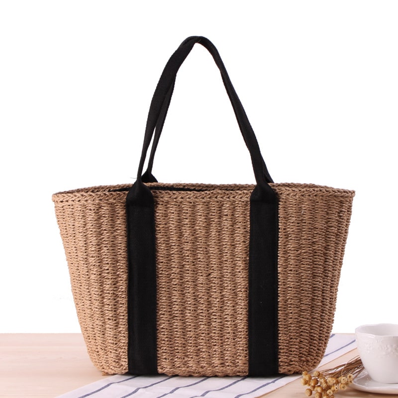 Tightly woven straw handbag with an adjustable strap and inner phone pocket