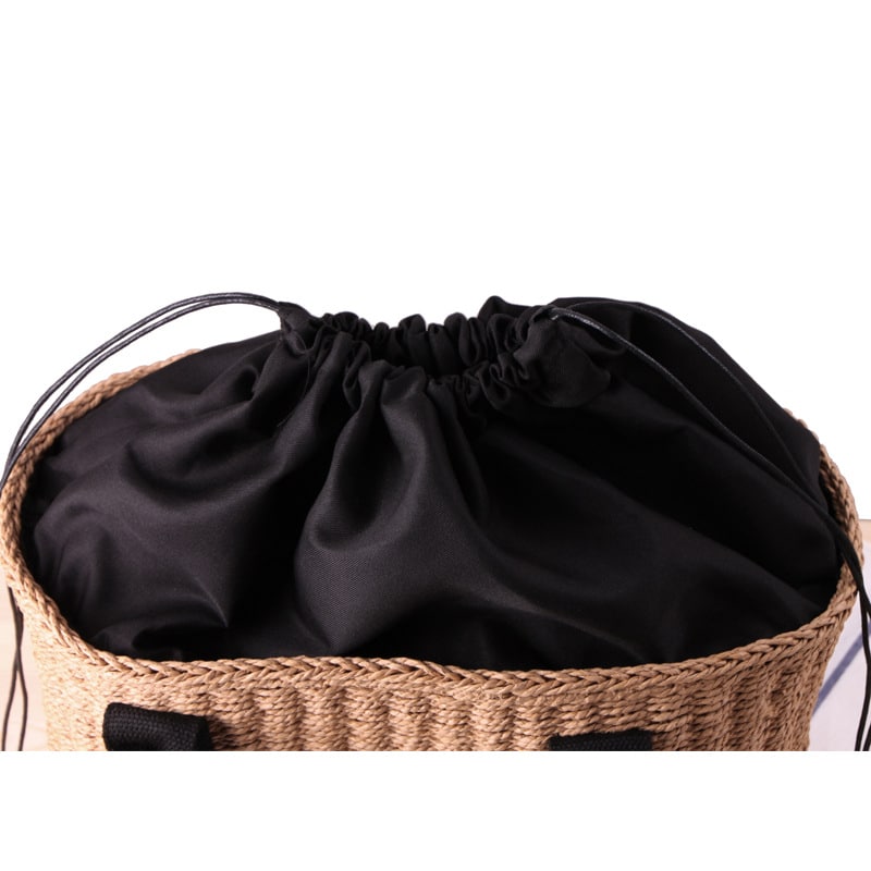 Tightly woven straw handbag with an adjustable strap and inner phone pocket