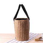 Tightly woven straw handbag with an adjustable strap and inner phone pocket