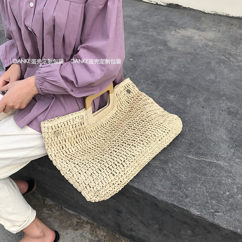 Woven straw tote bag with varnished wooden handles in beige or brown