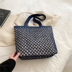 Structured woven tote bag with a top zip closure in blue or beige